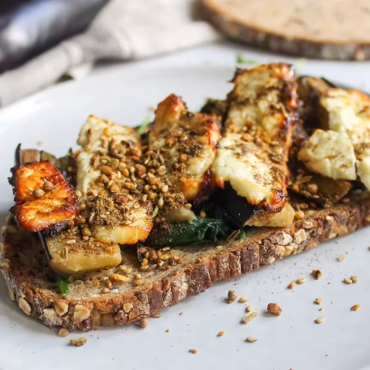 Tartine de féta grillée au miel avec aubergines et épices dukkah